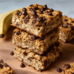 Chocolate chip banana oatmeal bars stacked on parchment