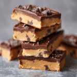 Cookie dough protein bars stacked with chocolate topping